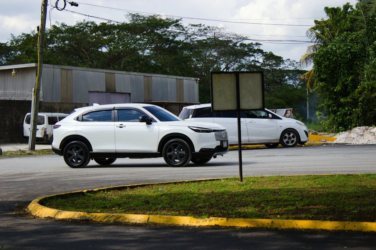 A white Honda Vezel parked outside a building
