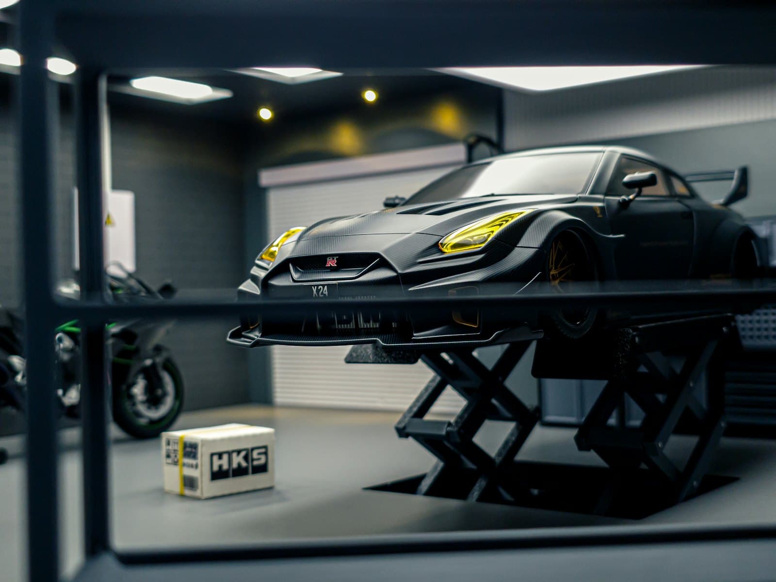 A Nissan GT-R on a hydraulic lift in a workshop